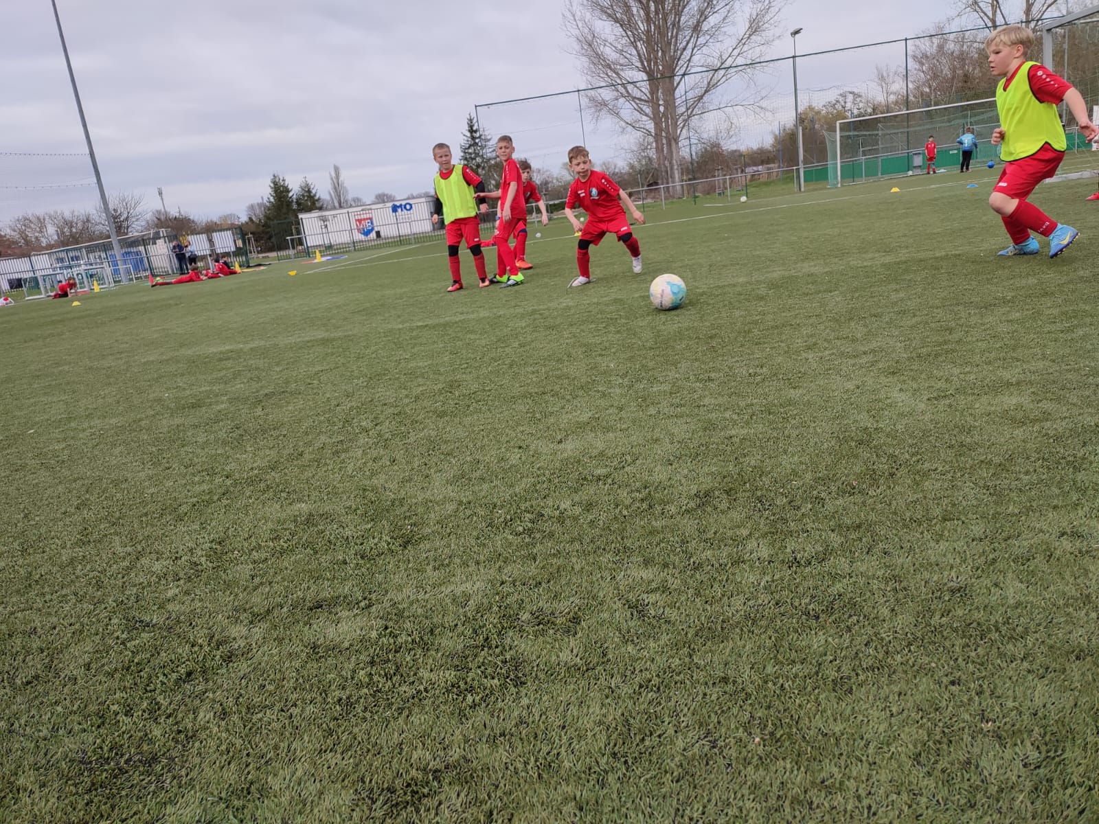 Kind mit Ball und voller Freude im Fußballcamp